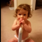 Bebé entretenida con cepillo de dientes electrónico