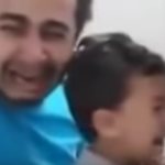 Un padre que llora desconsolado al vacunar a su hijo